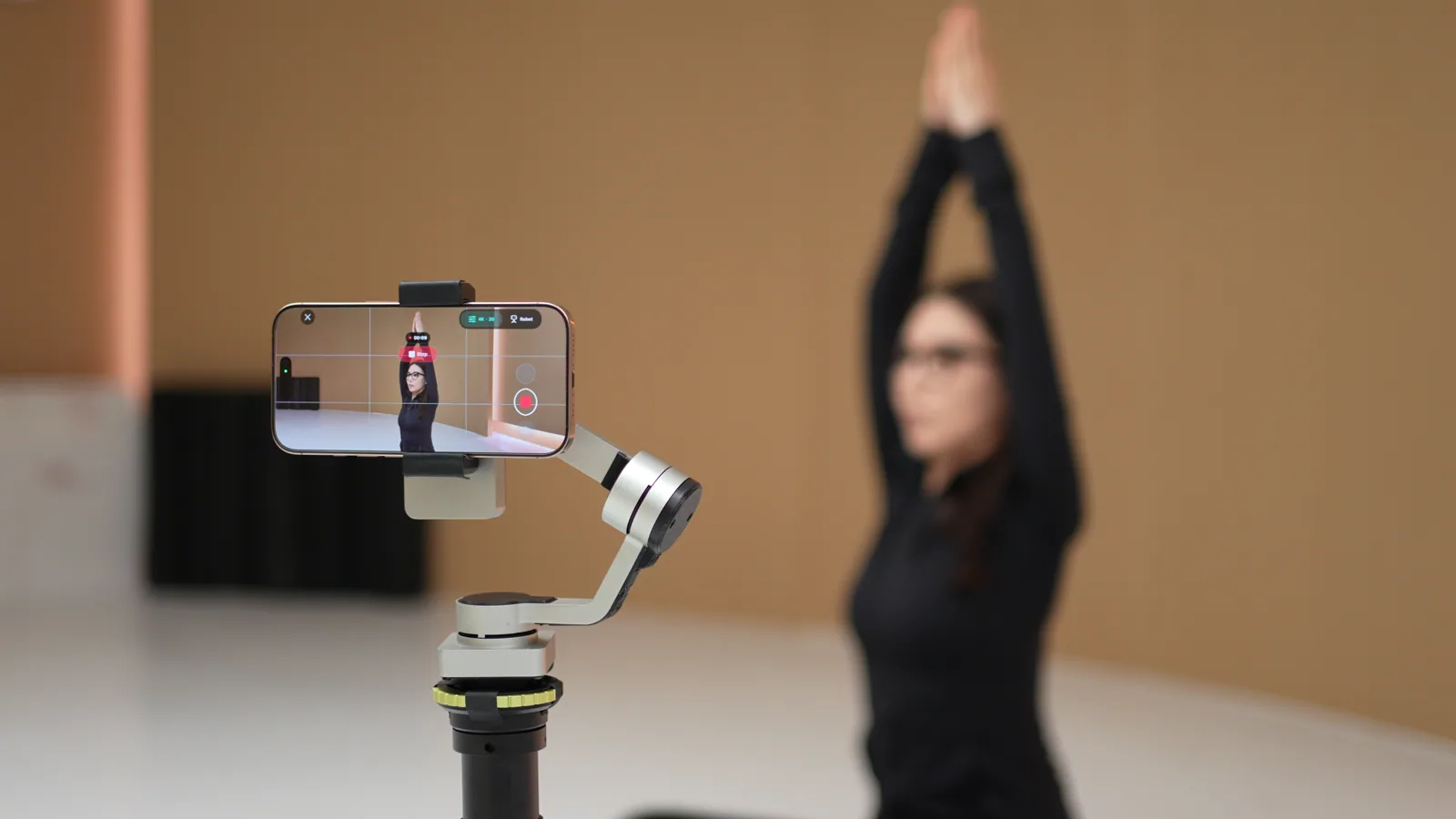 Tribot filming a yoga session with the subject visible on its phone screen